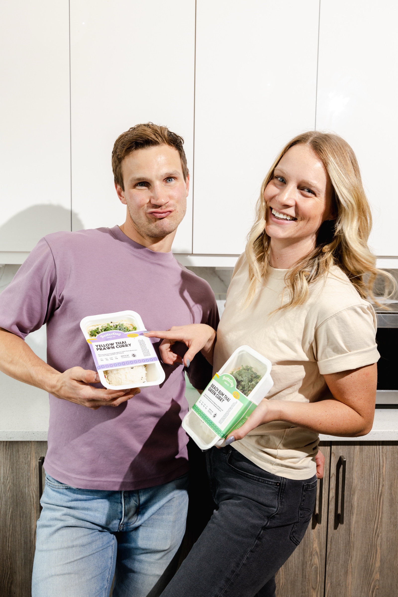 Amy and Conner holding BetterDay meals in the kitchen